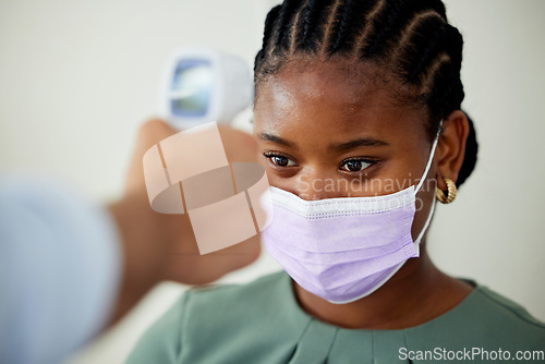 Image of Covid, mask or doctor with an infrared thermometer to take temperature and consulting a woman patient with a fever in an appointment. Healthcare, medicine and wellness with a female at the hospital