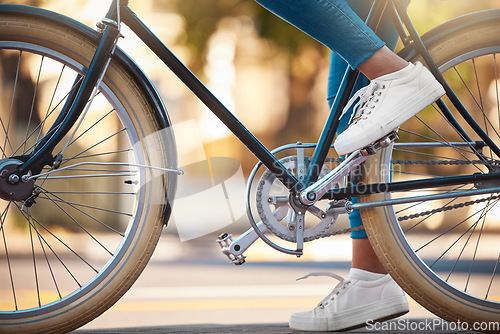 Image of Bike, shoes and cycling with a woman cyclist riding her bicycle outside on the road or street during the day. Sport, exercise and fitness with a female rider on transport with wheels and pedals