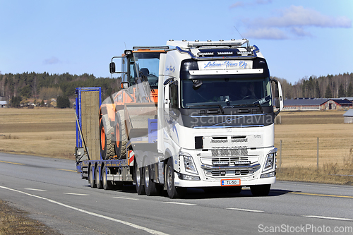 Image of White Volvo Truck Hauls Wheel Loader