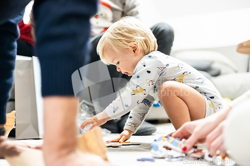 Image of Parents playing games with child. Little toddler doing puzzle. Infant baby boy learns to solve problems and develops cognitive skills. Child development concept