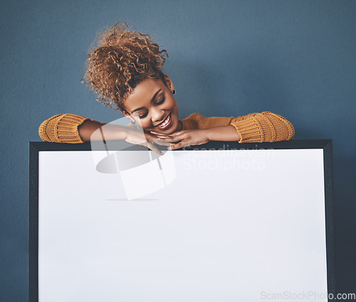 Image of Blank white poster and copyspace of a smiling, happy and young woman holding the sign. Female looking at an empty copy space board with a retail sale, marketing or social media advertising indoors