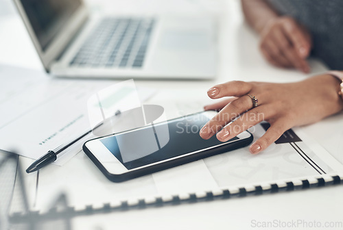 Image of Business woman, marketing analyst and entrepreneur browsing, texting and planning on a phone with a blank screen while working in an office. Closeup of a manager checking online notifications at work