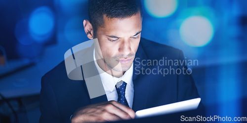 Image of Businessman with digital tablet overtime for data research in a corporate office at night. Male entrepreneur and executive worker using technology to communicate and network with online app or email