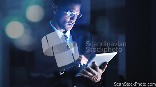 Image of Businessman working overtime on a digital tablet with glasses in a corporate modern office. Corporation manager reading company documents, data and statistics on an internet website with technology.