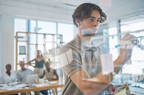 Image of Corporate team planning a strategy while writing on glass board to work on a project in an office. Creative group discussing business, research and marketing in meeting in the company conference room