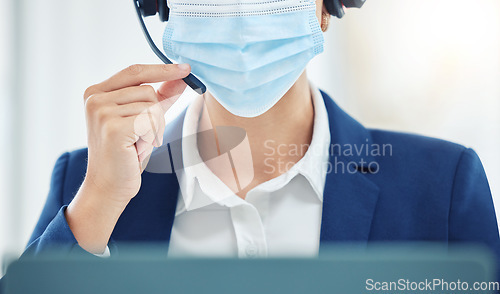 Image of Customer support, crm and covid compliance with face mask and an agent in office or center. Operator practice safety during online communication and advice. Woman working in hygiene, safe workplace