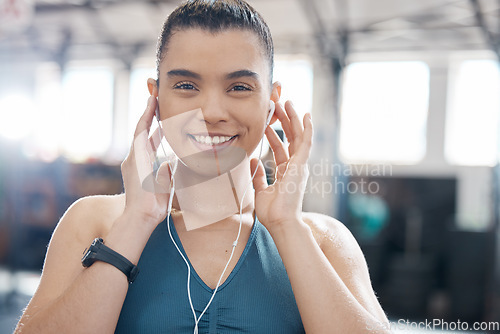 Image of Health, fitness and music by a woman at gym, streaming playlist while prepare for exercise or cardio workout. Portrait of a fit athlete enjoying a motivation podcast online, excited to begin warm up