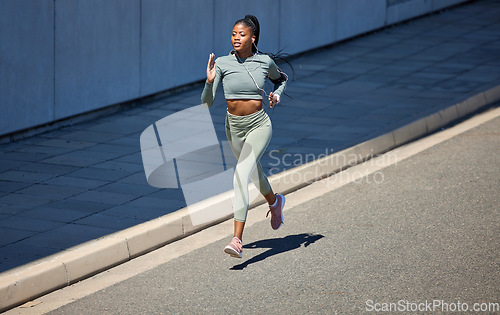 Image of City street, fitness and running woman with earphones listening to music or motivation audio for health workout with outdoor mockup. Black woman jogging or exercise training with a wellness podcast