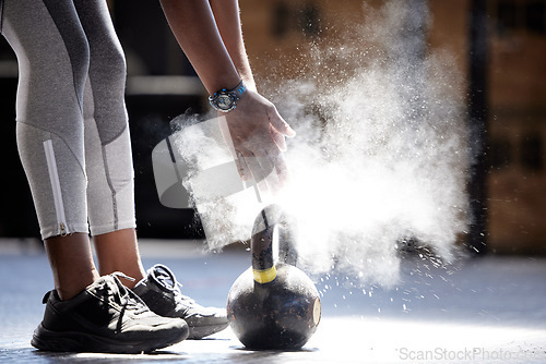 Image of Woman powder hands, kettlebell fitness and ready for gym training, workout and exercise in healthy club. Bodybuilder athlete with power, dust and motivation prepared for heavy performance challenge