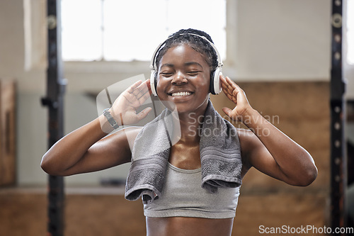 Image of Energy, fitness and music with happy black athlete training at gym, streaming motivation podcast online. African American woman enjoy exercise and healthy lifestyle, relax and stress relief cardio