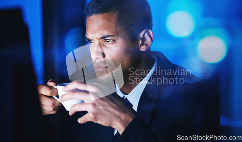 Image of Businessman drinking a cup of coffee while working overtime in the office at night time. Corporate, company and professional manager sitting at desk and analyzing data, documents and reports at work.