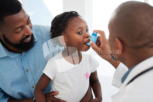 Image of Doctor helping a child patient with an asthma inhaler in his office at the medical clinic. Healthcare worker consulting a girl with chest or respiratory problems with pump in a childrens hospital