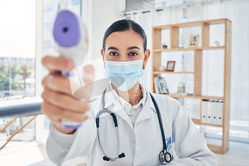 Image of Covid doctor thermometer, safety check and corona virus risk in hospital, clinic and medical surgery. Portrait of healthcare worker consulting with face mask, wellness service test and fever laser