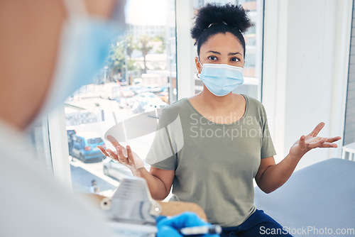Image of Covid, healthcare and frustrated patient in a hospital with a doctor annoyed at a delay during a medical appointment for consulting and advice. Woman in a mask feeling upset during medical checkup