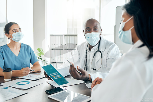 Image of Team of doctors with face mask consulting on covid results with paperwork and a digital tablet. Healthcare workers in a meeting to discuss the vaccine, treatment and medicine in a hospital office.