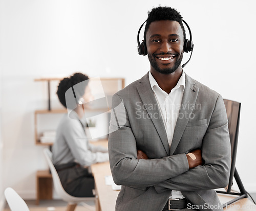 Image of Call center, customer service and crm consultant wearing headset and looking happy in telemarketing company. Portrait of confident black man in contact us and sales support department for assistance