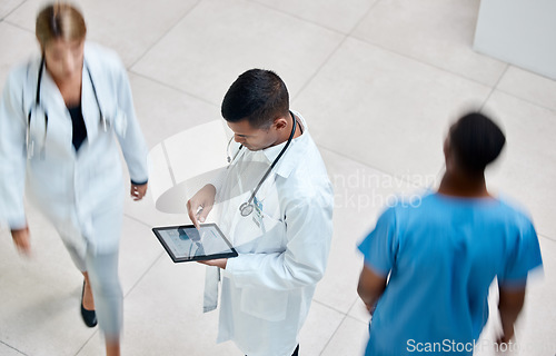 Image of Tablet, healthcare and medicine with a man doctor working in a busy hospital with urgency. Medical, research and insurance with professional workers in medicine rushing with blur in a clinic