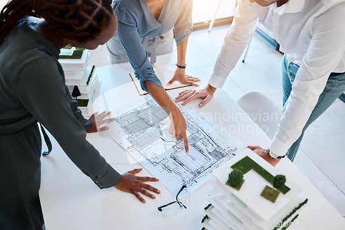 Image of Architect, team and planning building blueprint in office for coworkers to look at before construction. Workers looking at designs and scale model for future architecture in corporate work setting.