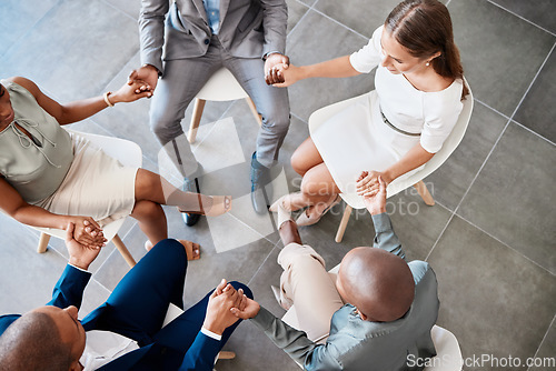 Image of Diversity, support and collaboration of business people holding hands above in trust for company success. Diverse group of corporate workers in a circle of unity for a meeting together at the office