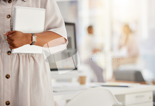 Image of Tablet, technology and internet with the hand of a business woman holding a wireless device in her office with colleagues in the background. Wifi, communication and networking with modern tech