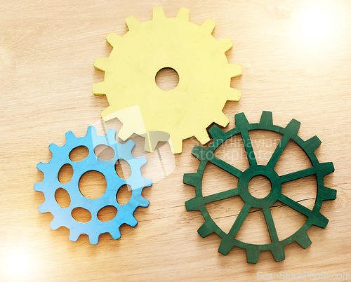 Image of Collaboration, engineering and construction concept with industrial gears, mechanics and cogs on a table or desk in an office. Teamwork, synergy and industry with the idea of building or design