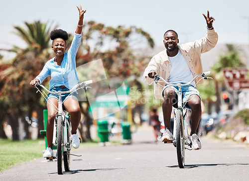 Image of African couple cycling on bike on vacation, peace hand sign on bicycle for sustainable lifestyle in the city and happy on holiday in summer for travel. Eco friendly man and woman in Miami for spring