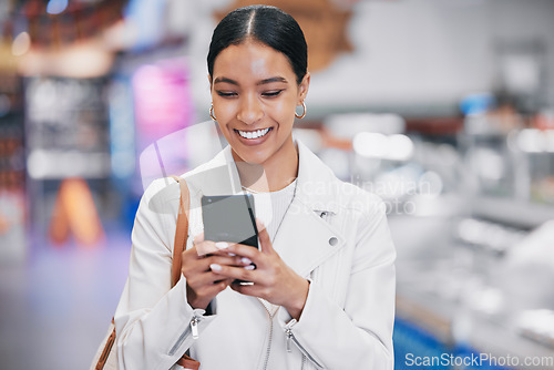 Image of Happy woman with phone reading funny social media meme on the internet while in a mall. Female with a smile while for discount coupon or texting a contact on a mobile smartphone after retail shopping