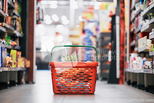 Image of Supermarket, shopping and store grocery basket on floor of retail food shop for eating, drinking and health. Pineapple, apple and fruit product sale at mall food market for a customer or consumer