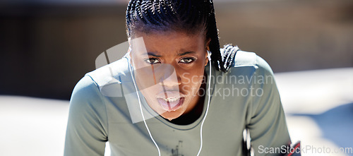 Image of Runner, workout and exercise athlete tired after running or training for a marathon with earphone. Health, wellness and motivation or healthy and strong fitness black woman relax after sports cardio