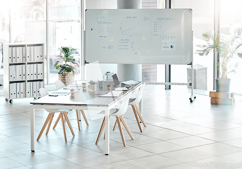 Image of Boardroom, meeting or empty conference room with whiteboard, chairs and table interior of modern creative office space. Marketing data and charts for a business presentation, discussion of briefing