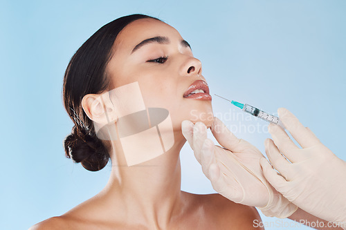 Image of Plastic surgery, collagen and lip filler for beauty aesthetic goal, youth and young face or facial appearance. Cosmetic surgery doctor hands work on woman, patient or client lips with blue background