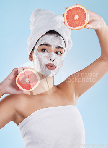 Image of Skincare, health and face mask on a woman with a grapefruit doing an organic facial in studio. Girl with wellness, selfcare and healthy lifestyle doing a body care routine with tropical citrus fruit.