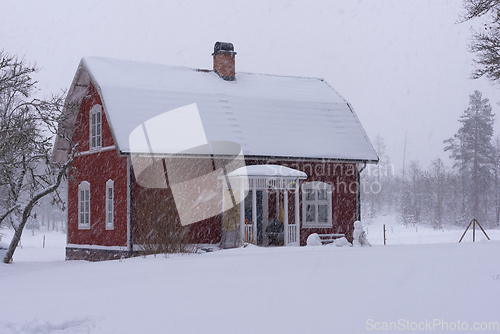 Image of Red wooden house in snowdrift