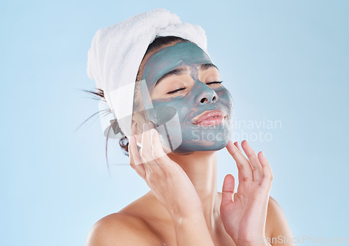 Image of Skincare, body wellness and charcoal face mask for healthy woman skin against blue mockup studio background. Young, happy and beauty cosmetic model with antiaging product for wellbeing and grooming