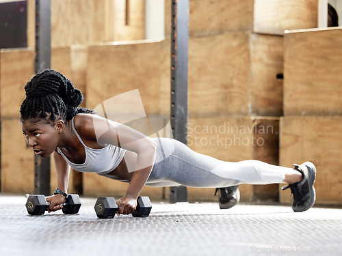 Image of Fitness, training and gym exercise of a sports black woman from Kenya with motivation and focus. African female sport workout with weights in a plank pose doing cardio in a wellness, health studio