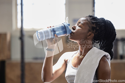 Image of Drinking water and relax after a fitness, workout and exercise training of a woman athlete. Female from Nigeria with sweat done reaching target cardio sports goal at a health, wellness and sports gym