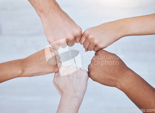 Image of Fist bump, unity and support group touching hands in a circle at a community therapy session. Top view of friends doing team building, care and trust exercise while bonding at a fellowship event.