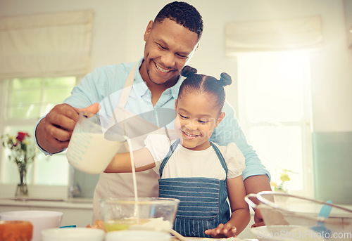 Image of Father teaching girl to bake and make dough in a messy kitchen. Caring parent and little daughter baking together in home while pouring milk into a bowl while having fun and bonding together.