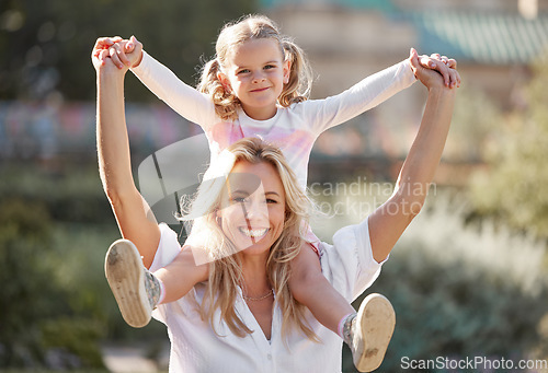 Image of Happy mother playing with daughter on her shoulders in their backyard on a sunny day. Energetic woman play and having fun with her girl. Family bonding and laughing together on the weekend