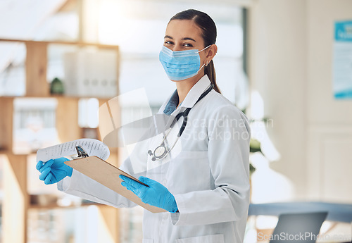 Image of Portrait of a doctor with paper and face mask doing medical paperwork during covid pandemic. Healthcare worker reading coronavirus results on a clipboard of hospital patient while standing in clinic.