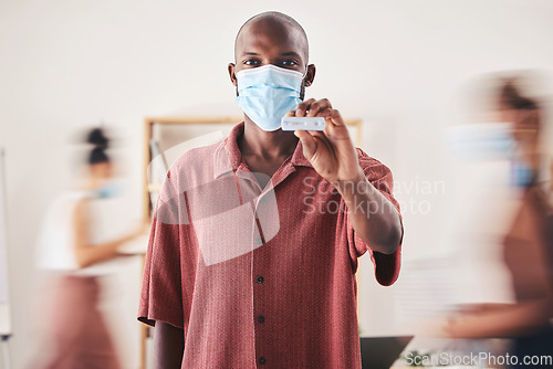 Image of Covid, rapid antigen test and face mask while standing and showing negative medical results. Portrait of a black man looking happy after coronavirus health screening during pandemic at his workplace