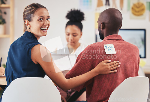 Image of Comic or funny business woman april fools prank or joke with coworker with paper note or sign on his back in corporate office. Smile, happy and joke or laugh and working at desk in corporate company