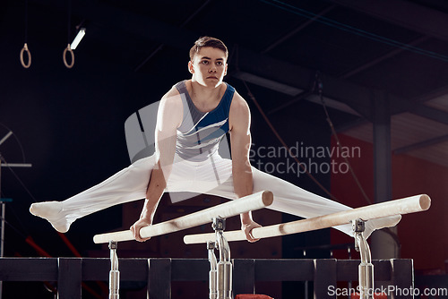 Image of Gym, man and training for balance and fitness in professional gymnastics for cardio sports workout at night. Young athletic guy in dark competitive acrobat exercise in sport practice for competition.