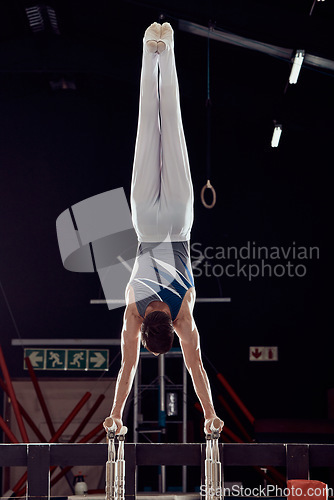 Image of Strong man training for fitness in gym, cardio sports exercise at stadium at night and sport workout for health and wellness in dark arena. Young athlete person doing gymnastics in competition