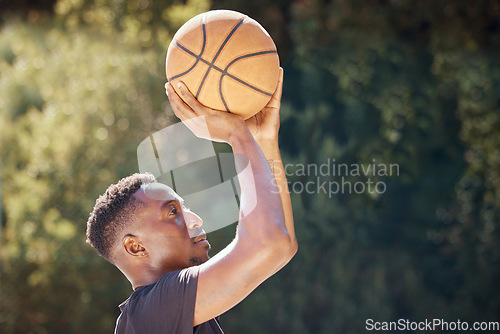 Image of Basketball, sports and exercise workout of a man doing fitness, health and cardio training. Focus mindset of athlete shooting a ball to practice his aim for a sport game or match on a outdoors court