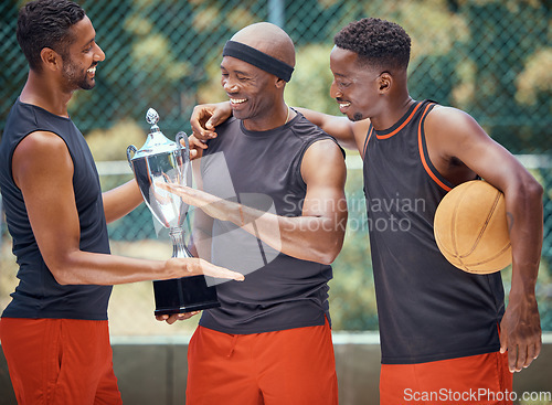 Image of Award, success and basketball athletes with a trophy as a reward or prize after winning a competitive sports game. Challenge, fitness and happy African winners in celebration after mens championship