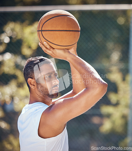 Image of Basketball player, sports and training with fitness man with ball ready to shoot or throw while playing at an outdoor court. Serious athlete doing exercise or active game for health and wellness