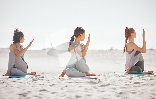 Image of Zen, heath and yoga group meditation on a beach with women training and meditating together. Athletic friends exercise, practice posture and balance yoga pose with zen, peaceful energy in nature