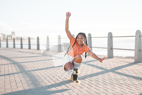 Image of Fashion black woman, roller skating or fun by beach, sea or ocean brick street in Miami, Florida. Portrait of smile, happy or playful student with trend, style or cool clothes in freedom sports stunt