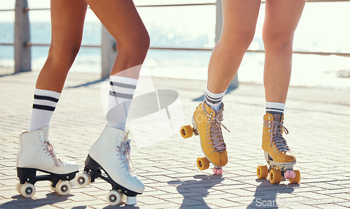 Image of Roller skates or fun friends on promenade for summer holiday activity or travel outdoor. Cool, trendy or funky women skating legs in quad skating or rollerblades with sunshine, beach and ground